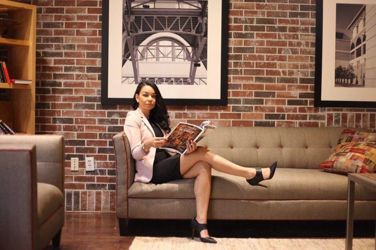 Woman reading magazine on couch.