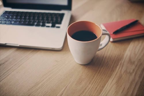 Coffee, laptop, and notebook.