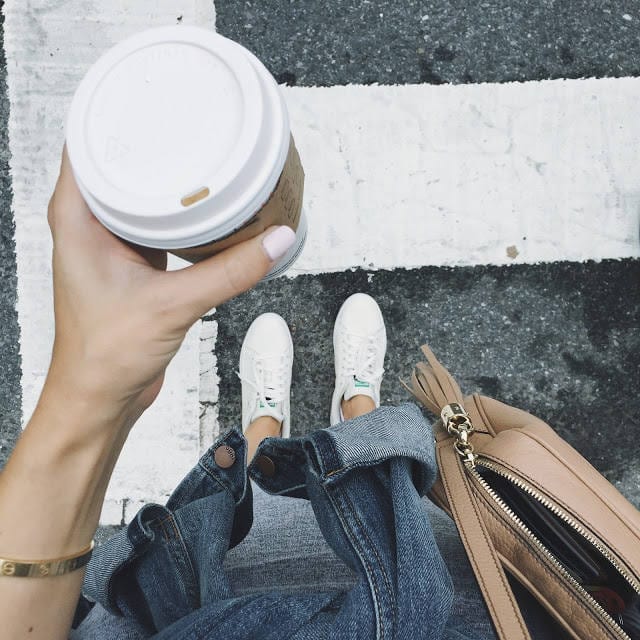 Woman holding coffee cup and bag