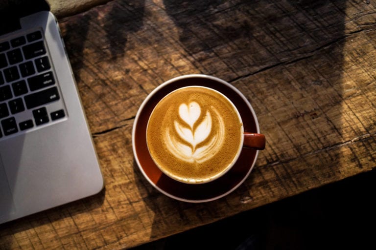 Coffee and laptop on table