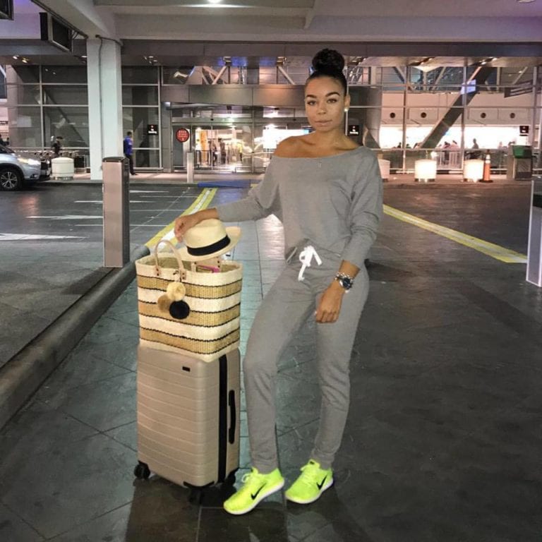 Woman with luggage at airport.