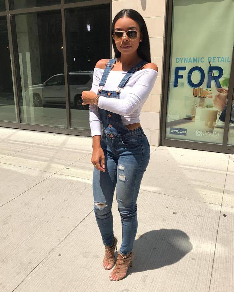 Woman in denim overalls outside.
