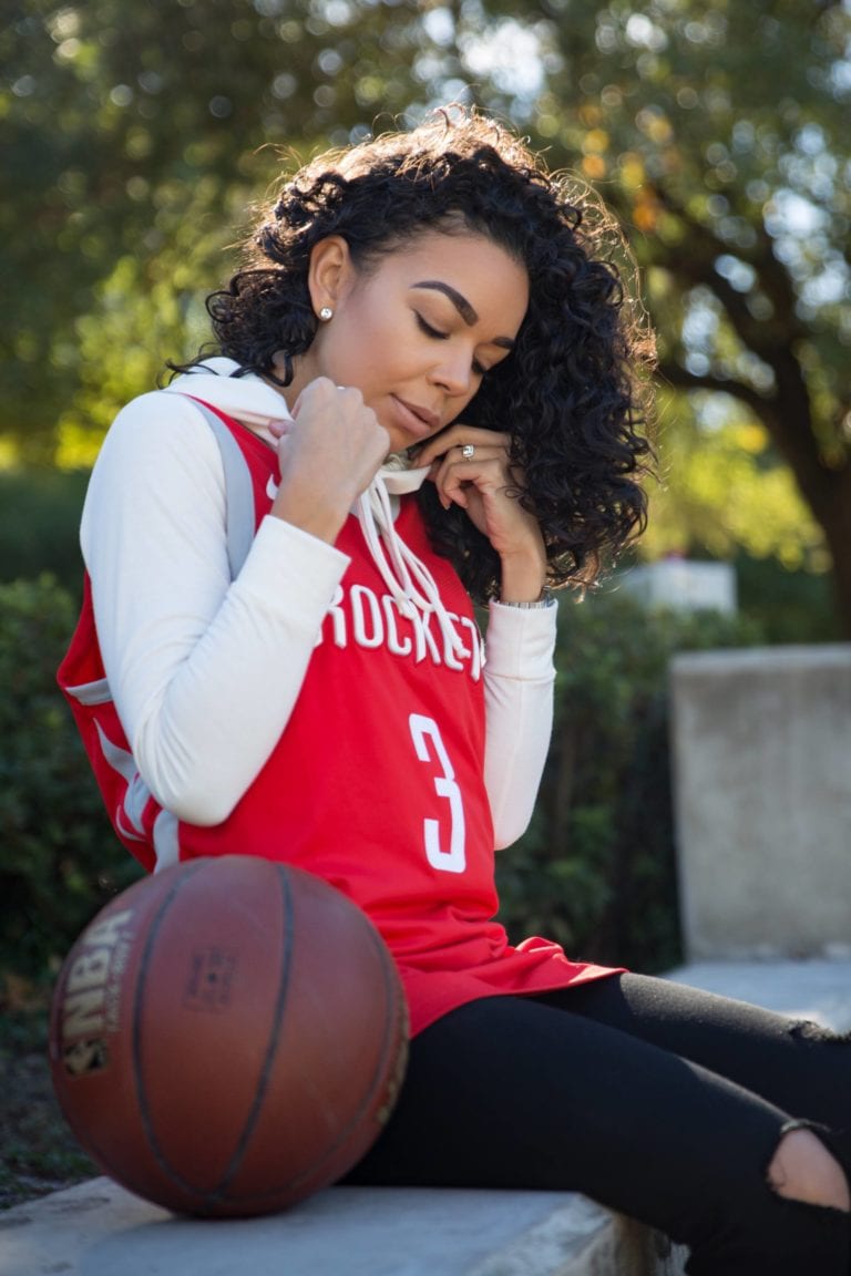 Woman in basketball jersey and jeans.
