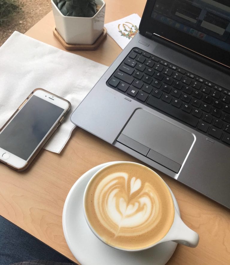 Coffee, laptop, and phone workspace