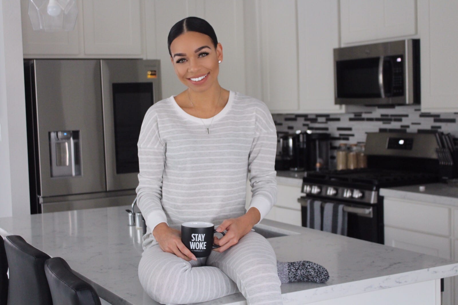 Woman holding coffee in kitchen