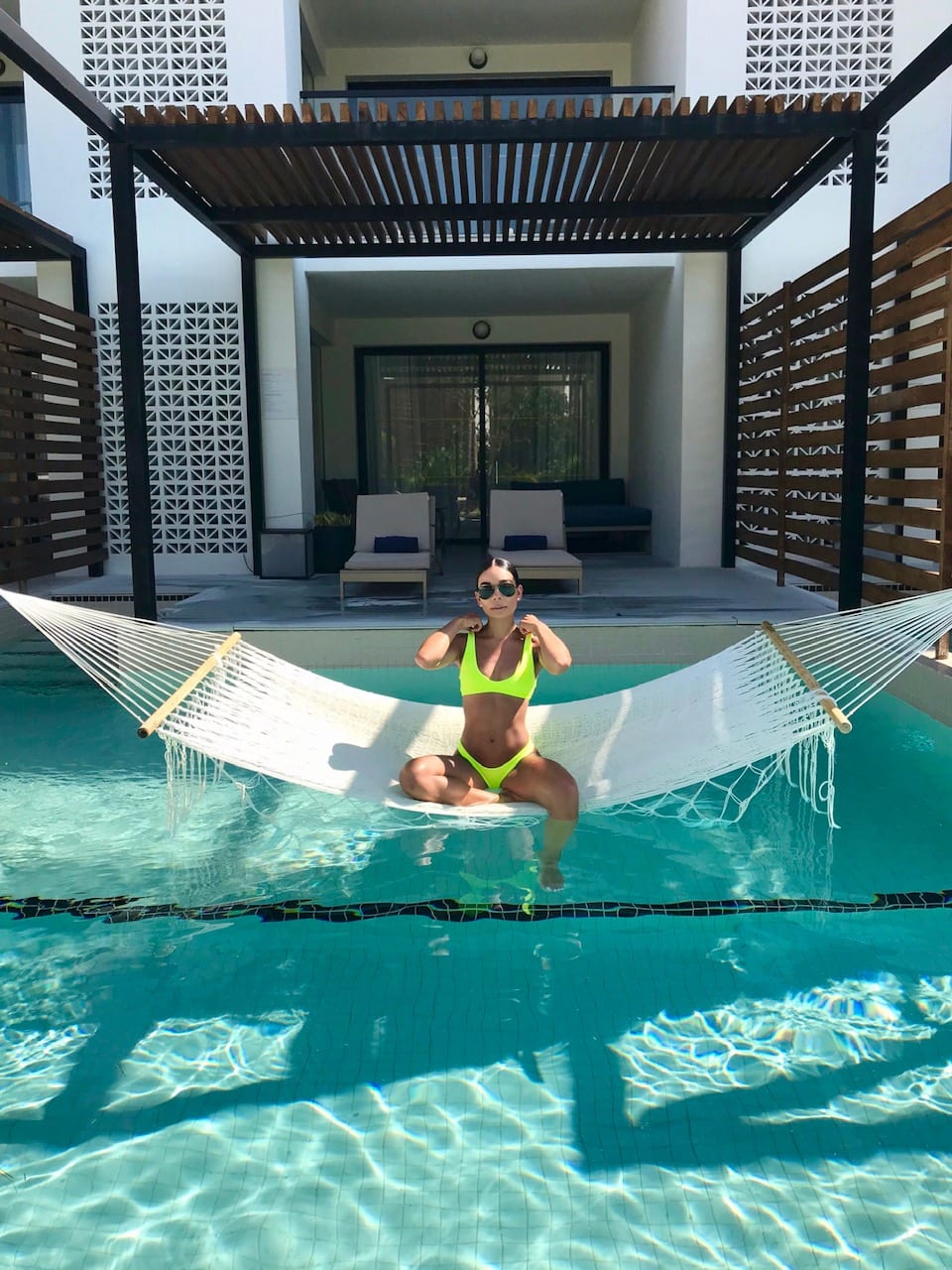 Woman relaxes in pool hammock