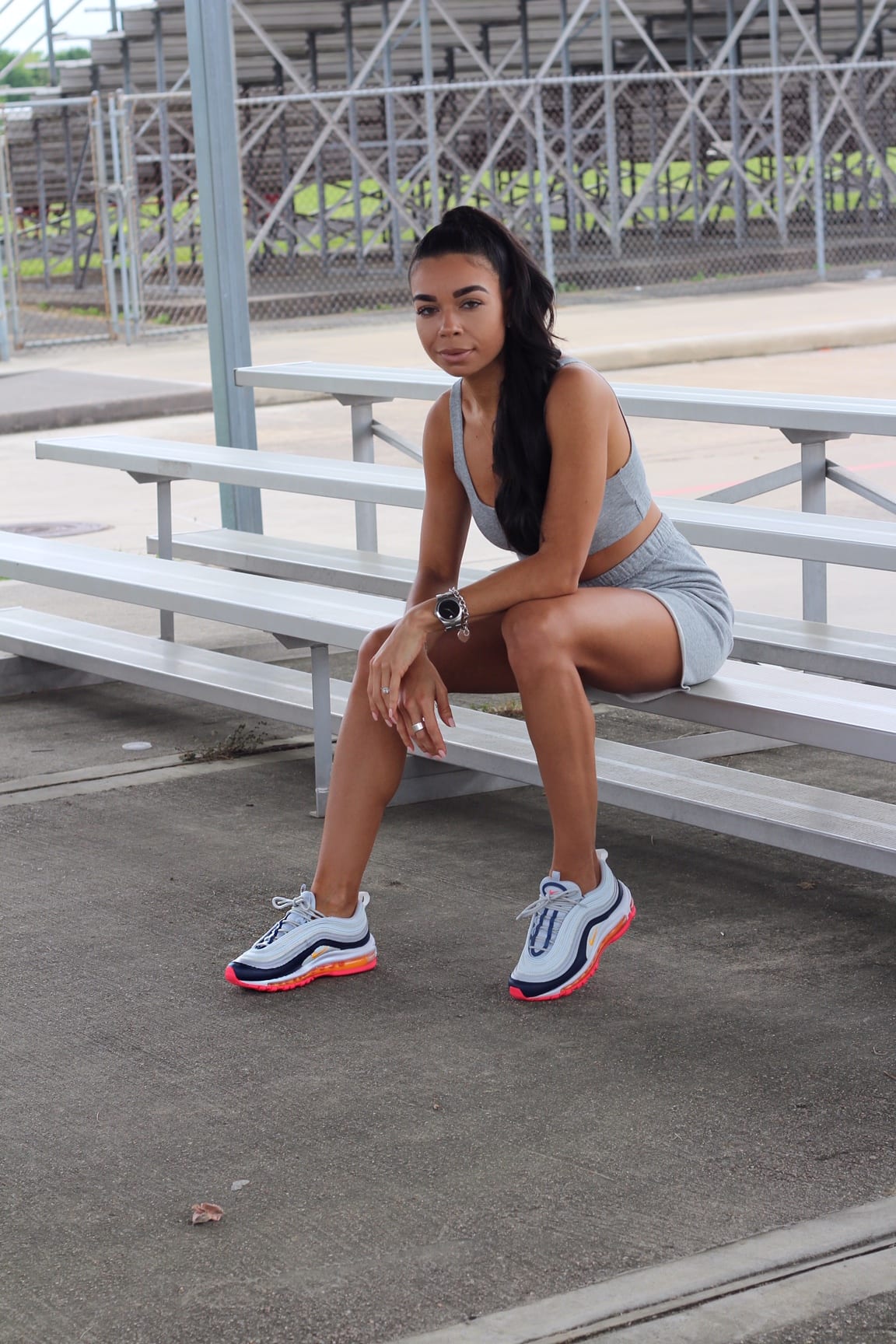 Woman in athletic wear sits.