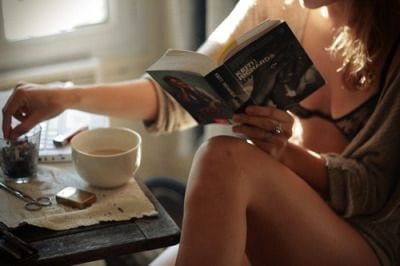 Woman reading book with tea