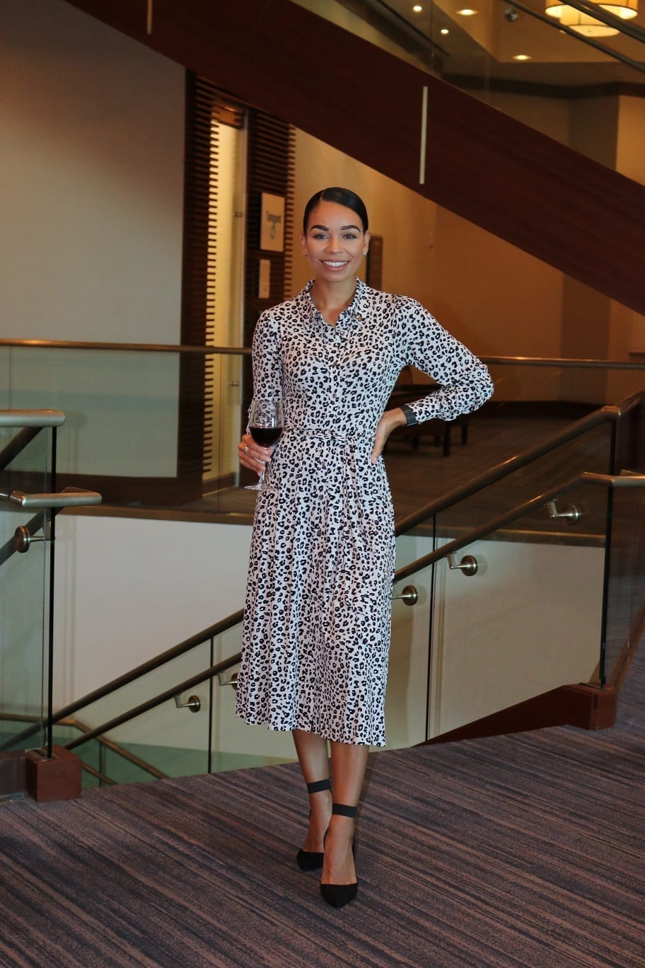 Woman in patterned dress poses.
